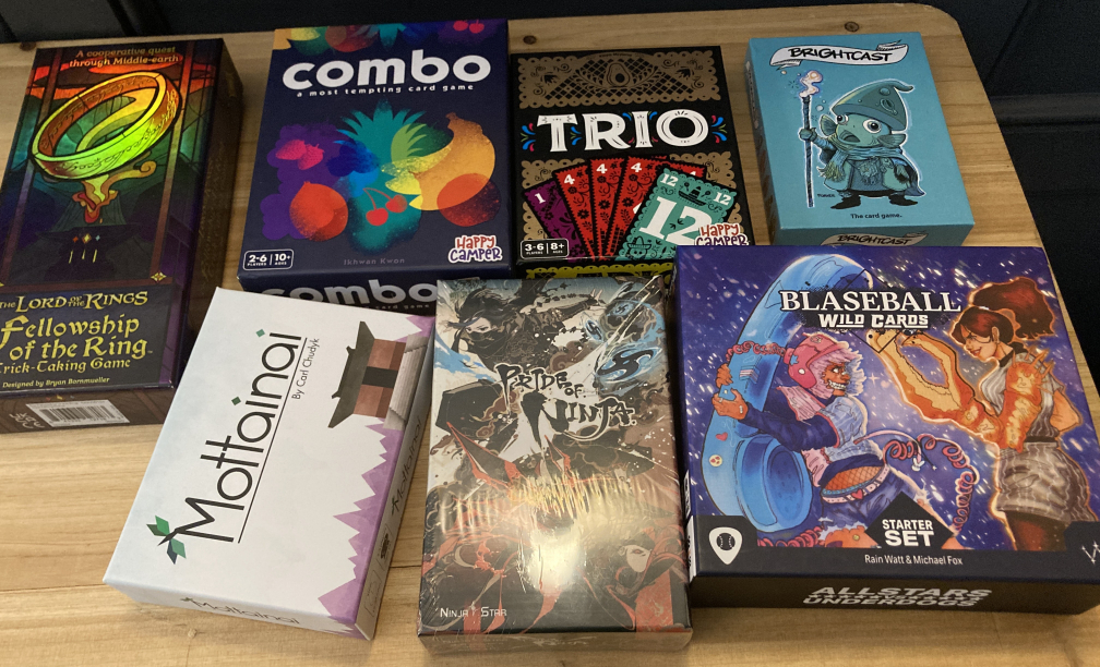 Image of 7 board games, LoTR trick taker, Combo, Trio, Brightcast, Mottanai, Pride of Ninja, and Blazball